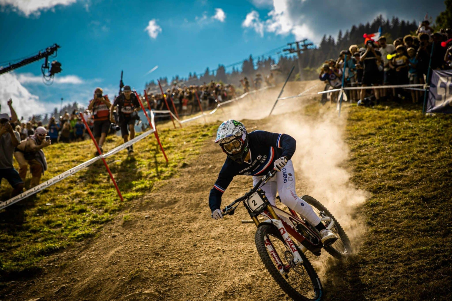 downhill mountain biker with dust cloud