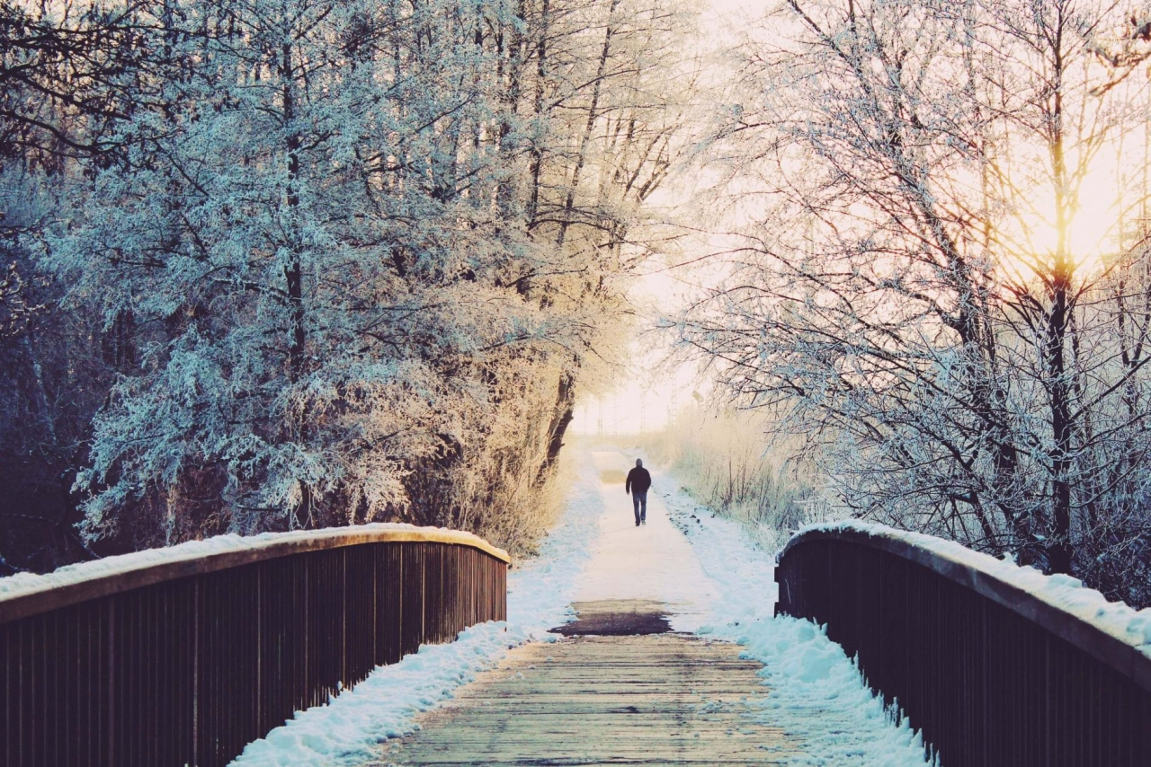 man walks along bridge whilst snowshoeing along the dereche in Morzine