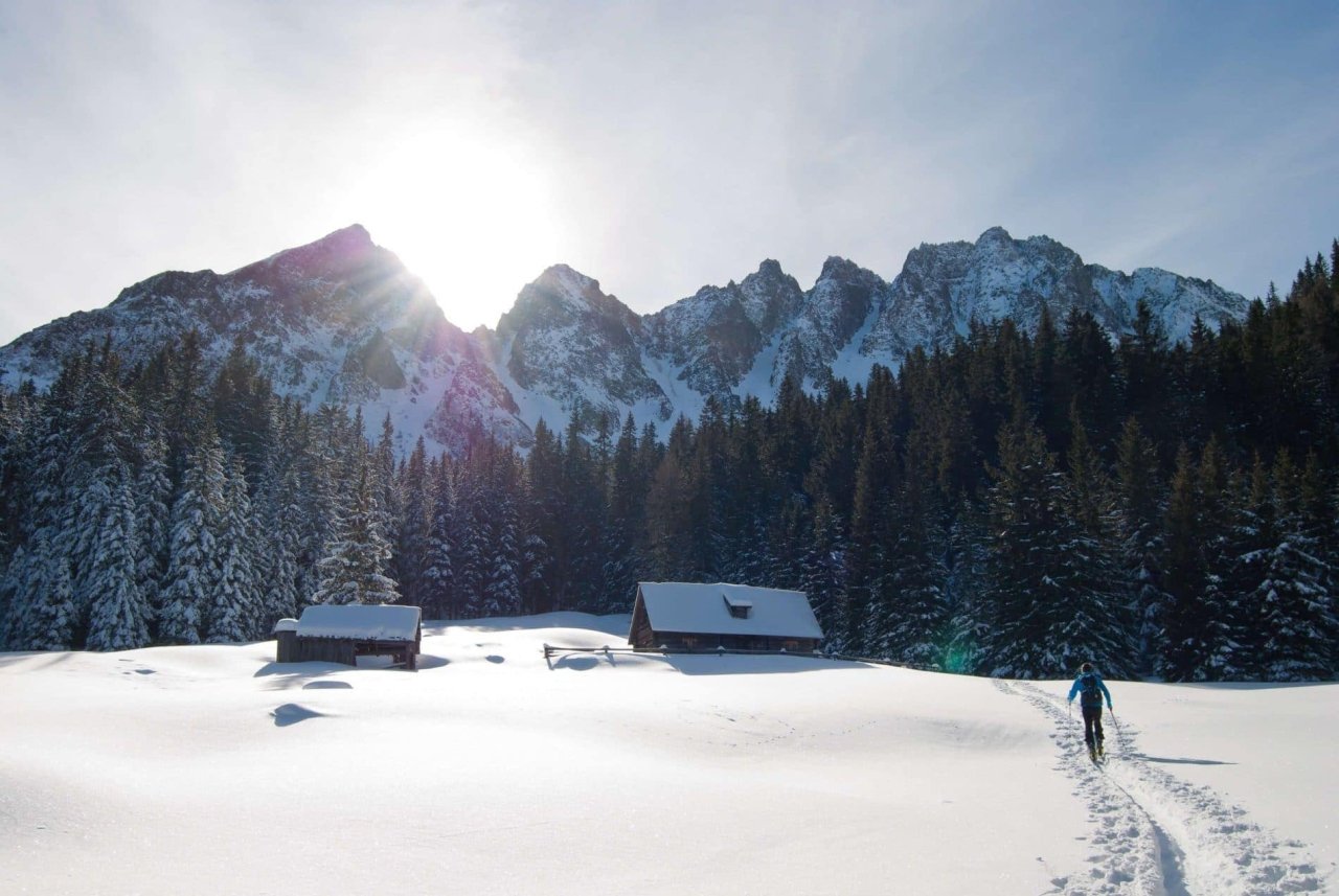 man snowshoeing in Morzine through snowy mountain hamlet